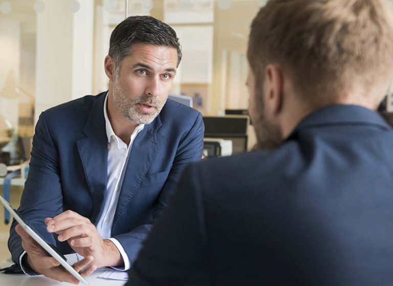 Businessman discussing over digital tablet with male colleague a